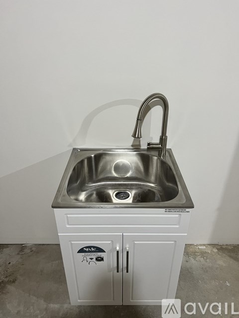 A kitchen sink with a faucet and a cabinet below it.