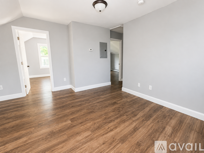 A room with wooden flooring and white walls.