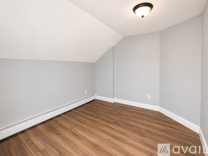 A room with wooden flooring and white walls.