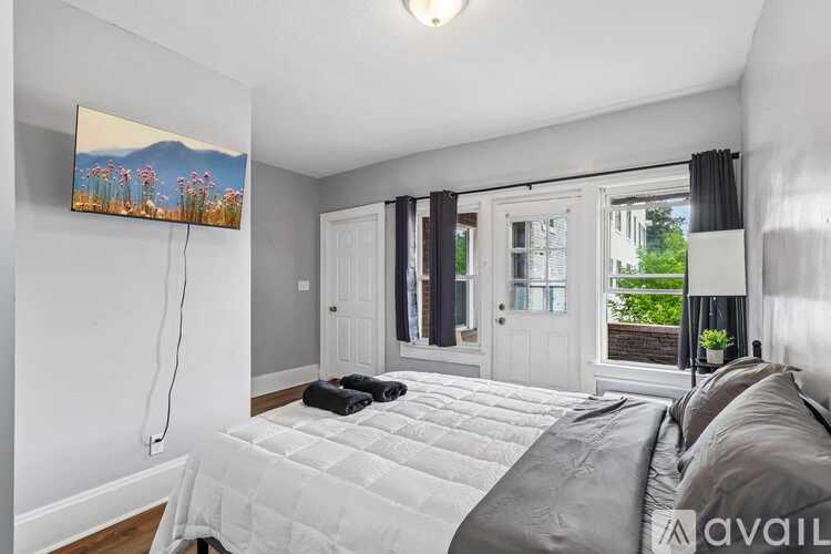 A bedroom with a large bed and a painting on the wall.