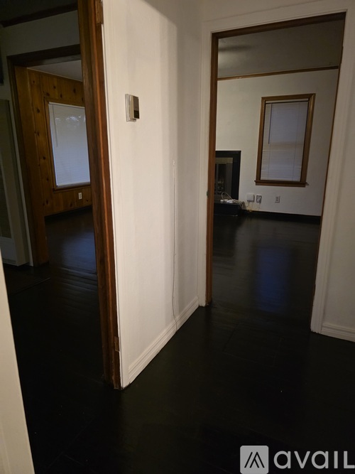 A hallway with a white door and a mirror on the wall.