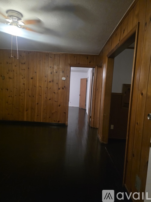 A room with wooden walls and a ceiling fan.