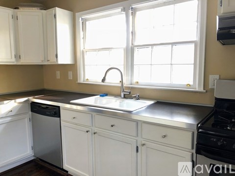 A kitchen with white cabinets and a stainless steel dishwasher.