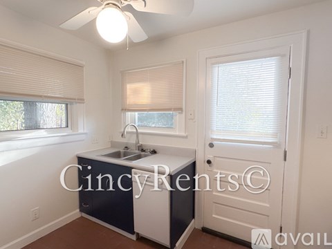 A kitchen with a sink and a window with blinds.