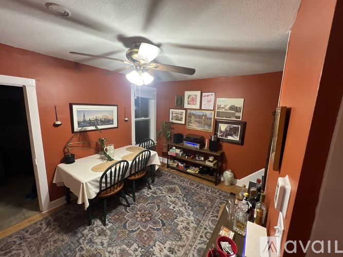 A dining room with a table set for two and a ceiling fan.