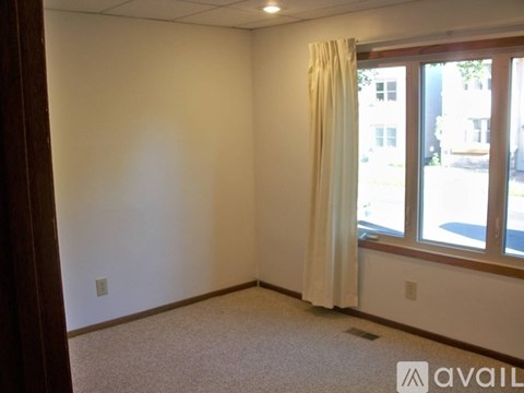 A room with a window and a carpeted floor.