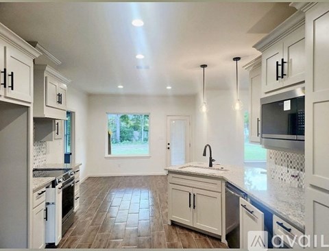 A spacious kitchen with white cabinets and a central island.