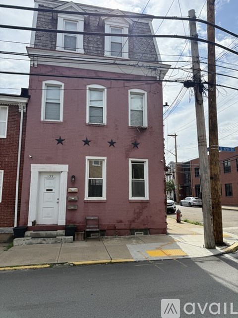 A red building with a white door and windows with stars on the front.