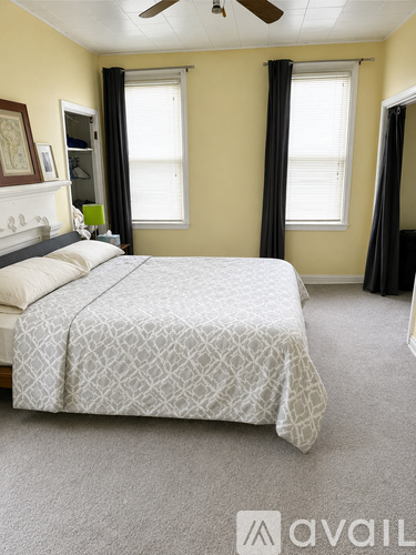 A bedroom with a large bed and a ceiling fan.