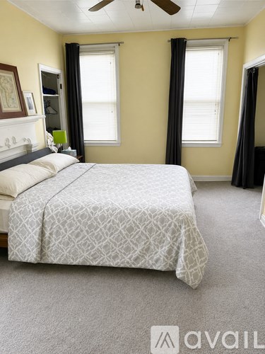 A bedroom with a large bed and a ceiling fan.