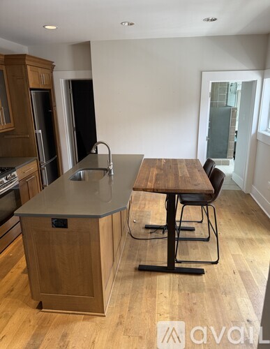 A kitchen with a wooden island and a dining table with chairs.