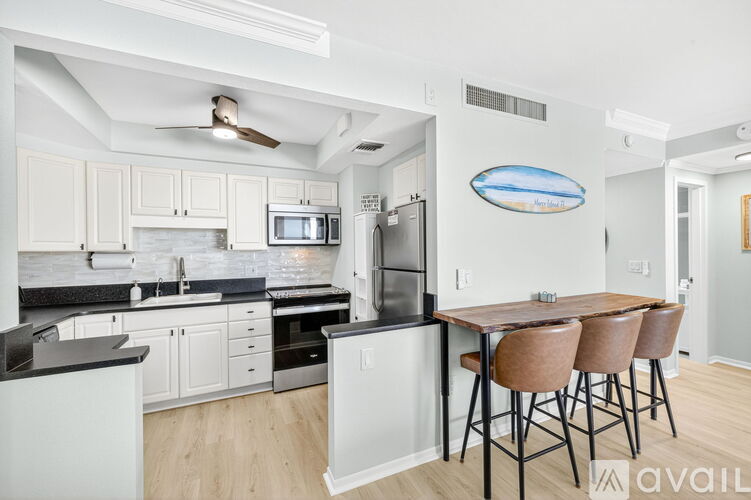 A kitchen with a table and chairs in the foreground and a fridge in the background.