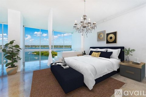 A bedroom with a large bed and a view of the ocean.