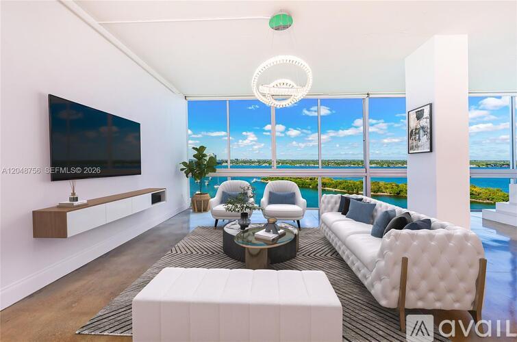 A living room with a large window overlooking the water.
