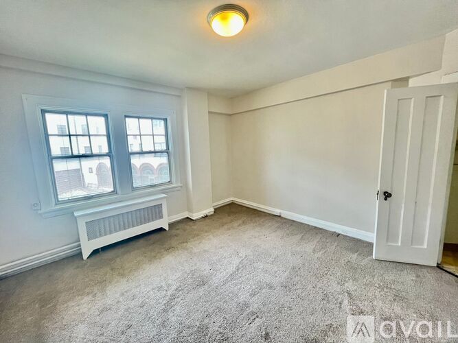 A room with a window and a bench is available for rent.