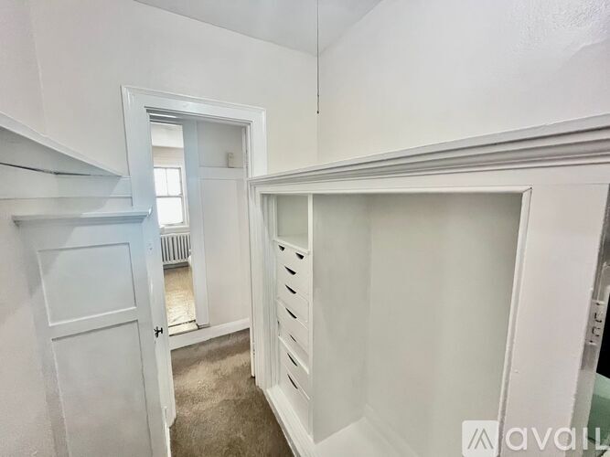 A white room with a door and a window.