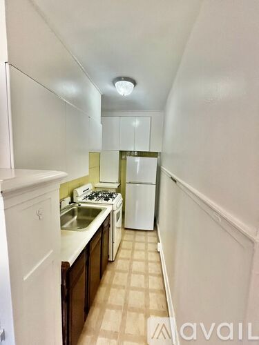 A small kitchen with white cabinets and a sink.