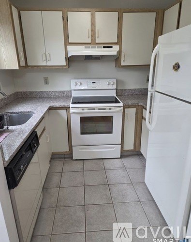 A kitchen with white appliances and a white refrigerator.