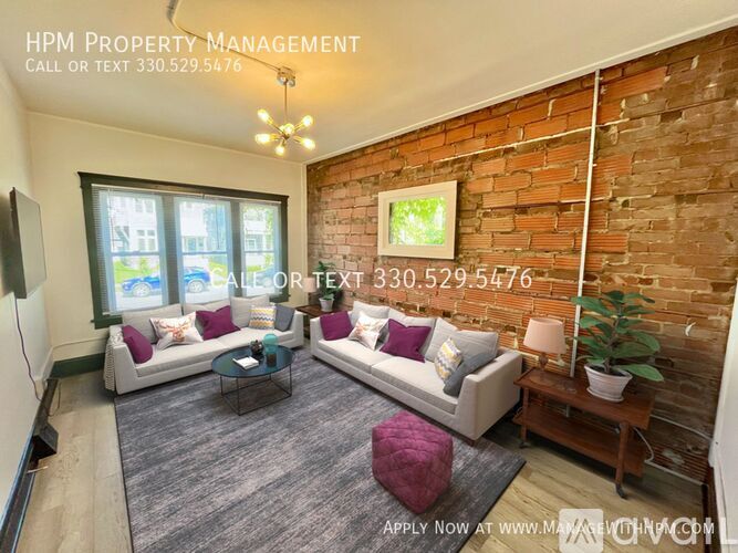 A living room with a brick wall and a couch.