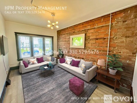 A living room with a brick wall and a couch.