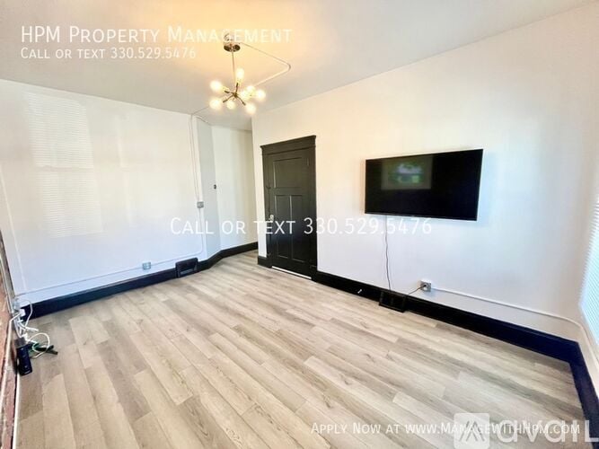 A room with a wooden floor and a door is for rent.