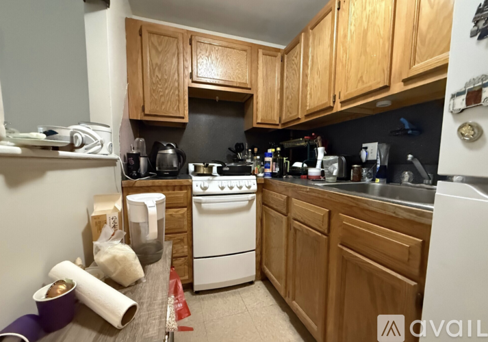 A kitchen with wooden cabinets and a white stove.