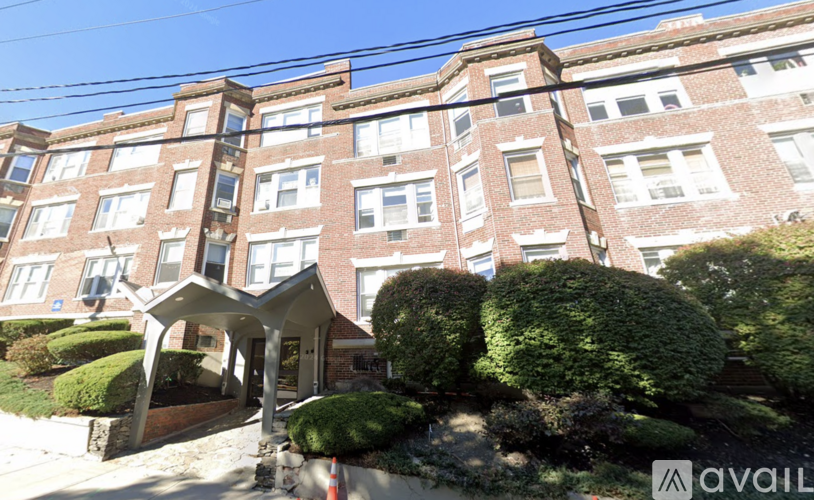 A building with a brown brick facade and a white trim around the windows.
