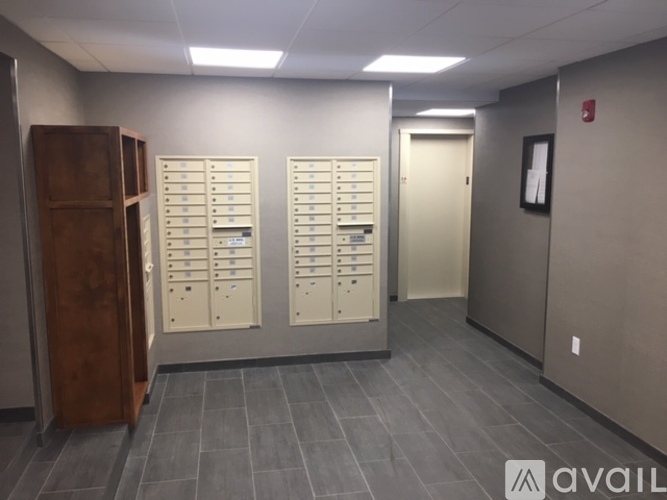 A room with a row of lockers and a wooden cabinet on the left.