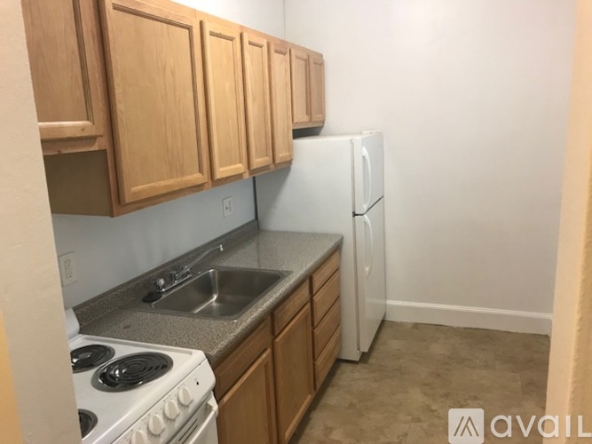 A kitchen with wooden cabinets and a white stove top oven.