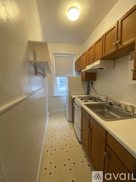 A kitchen with a white fridge, wooden cabinets and a dishwasher.
