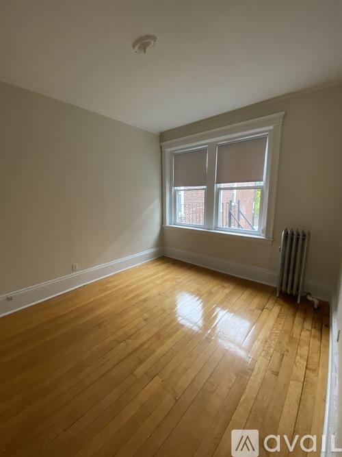 A room with wooden flooring and a window.