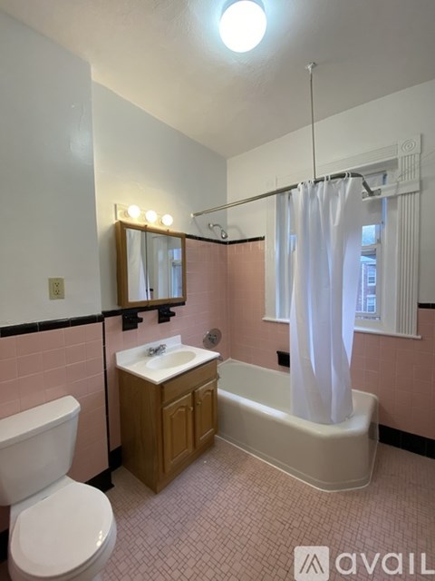 A bathroom with a toilet, sink, and bathtub.
