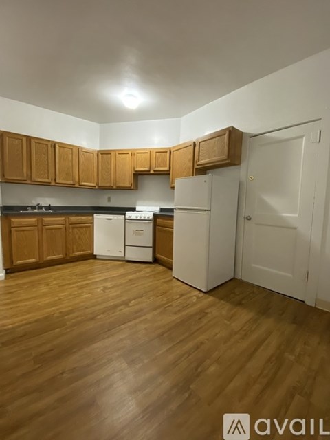 A kitchen with wooden cabinets and a white fridge.