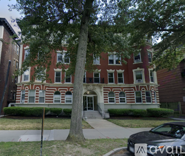 A large red brick building with a tree in front.
