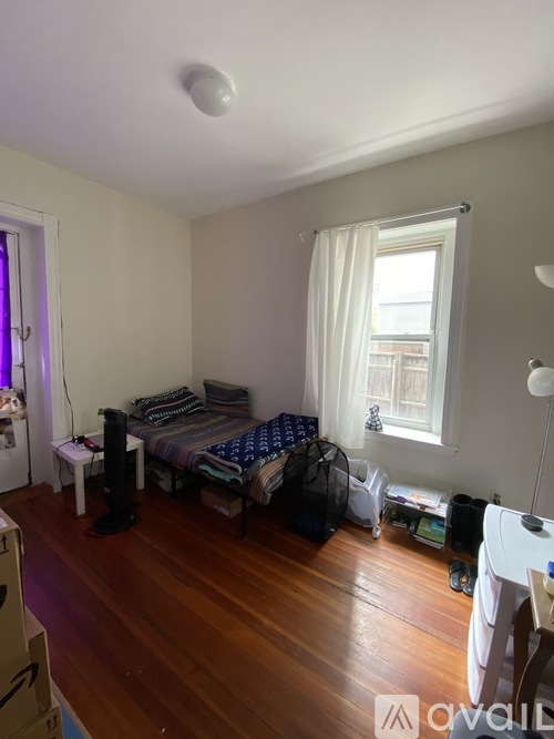A bedroom with a bed, a chair, and a window.