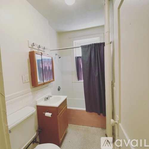 A bathroom with a toilet, sink, and shower.