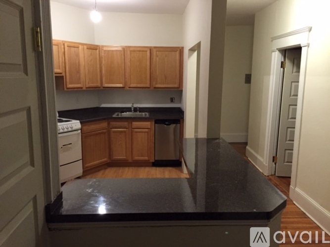 A kitchen with wooden cabinets and a black countertop.