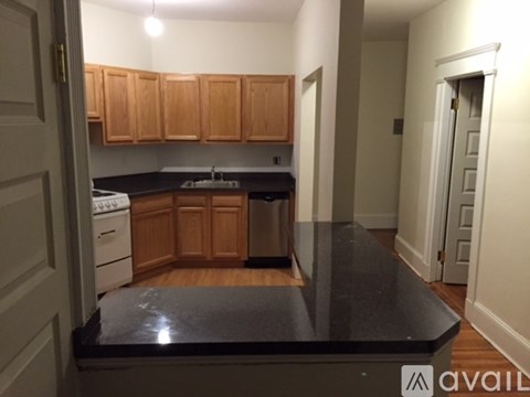 A kitchen with wooden cabinets and a black countertop.