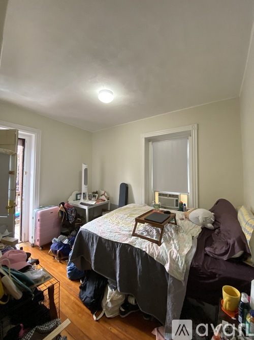 A bedroom with a bed, a chair, and a desk.