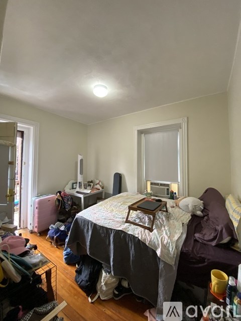 A bedroom with a bed, a chair, and a desk.