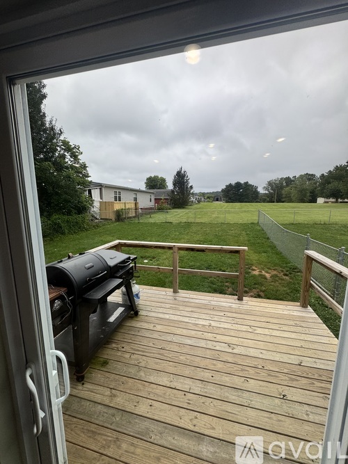 A view from a deck looking out to a grassy field.