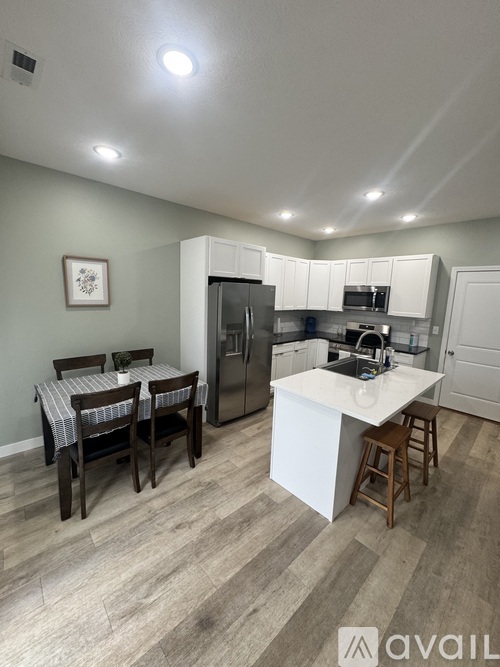 A kitchen with a table and chairs in the middle of the room.