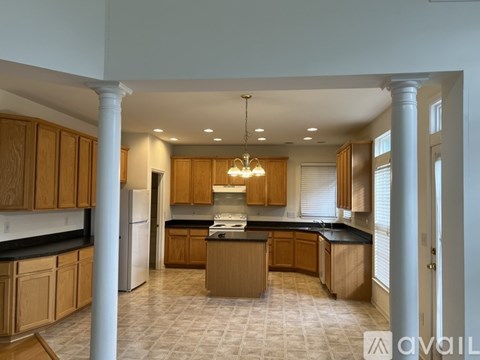 A kitchen with wooden cabinets and a tiled floor.