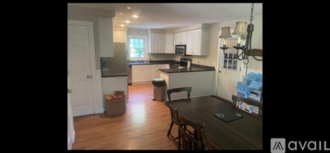 A kitchen with a dining table and chairs.