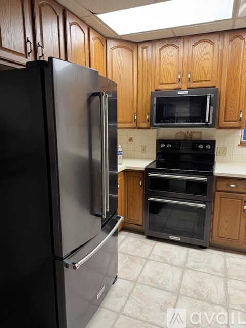 A kitchen with a black refrigerator and an oven.