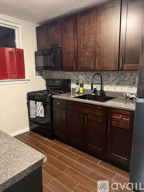 A kitchen with wooden cabinets and a black stove top oven.