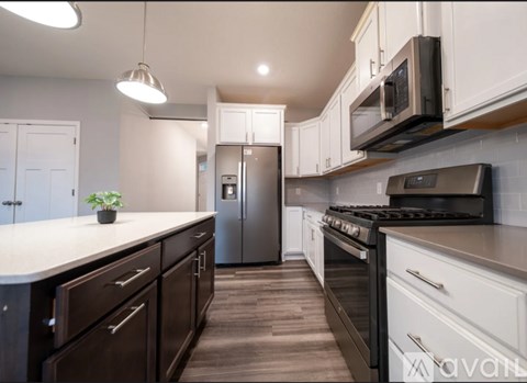 A kitchen with white cabinets and a black stove top oven.