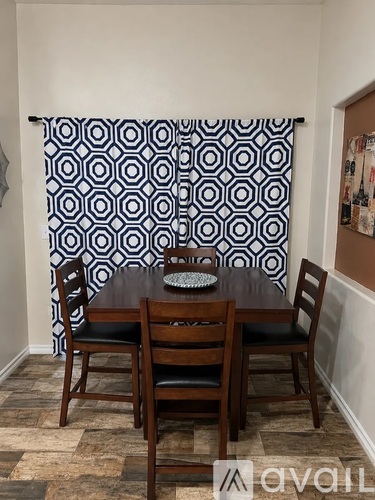 A dining room with a table and chairs.