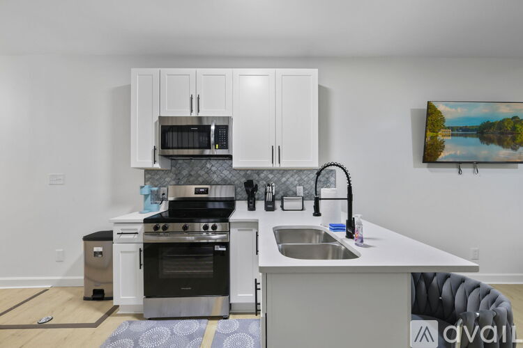 A kitchen with white cabinets and a black stove top oven.