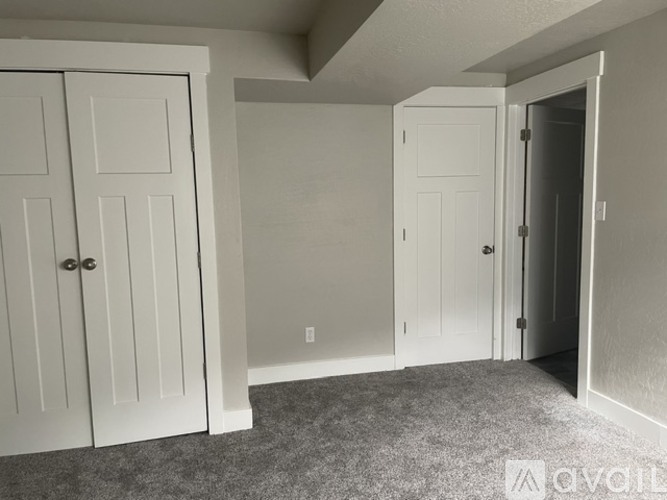 A room with white doors and a carpeted floor.